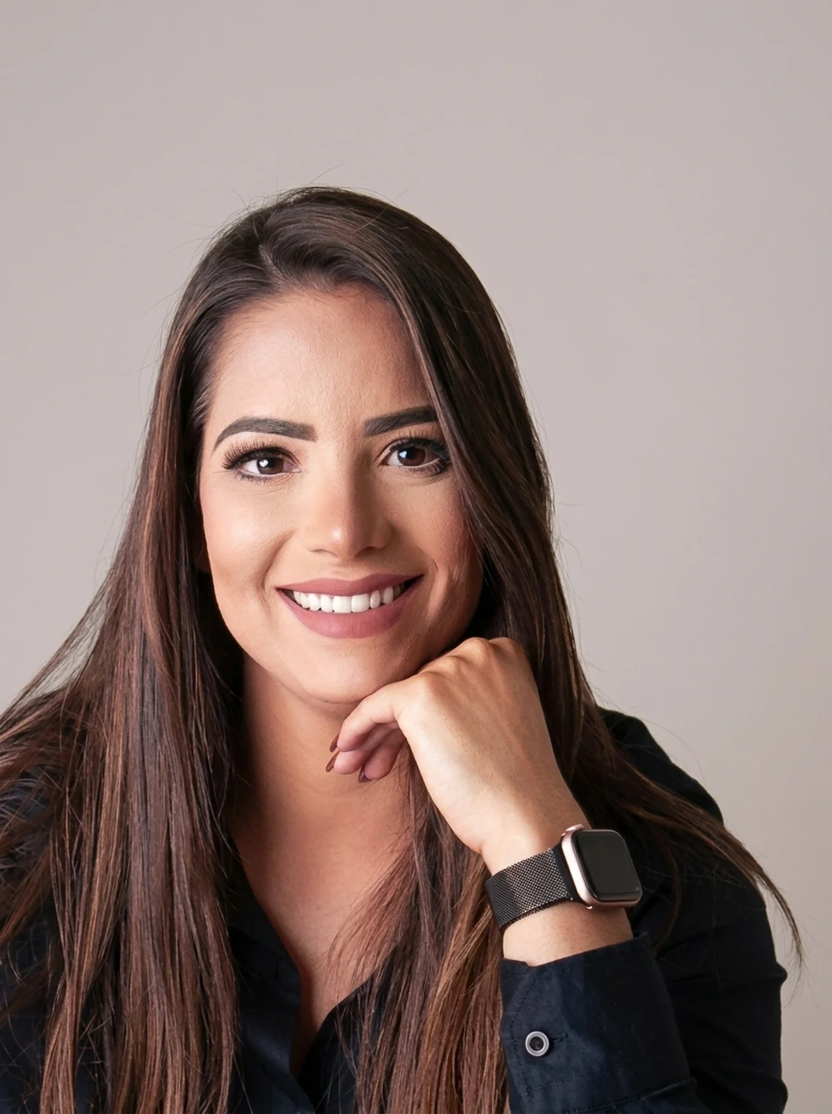 Juliana Alves, sorrindo, com a mão apoiada no queixo